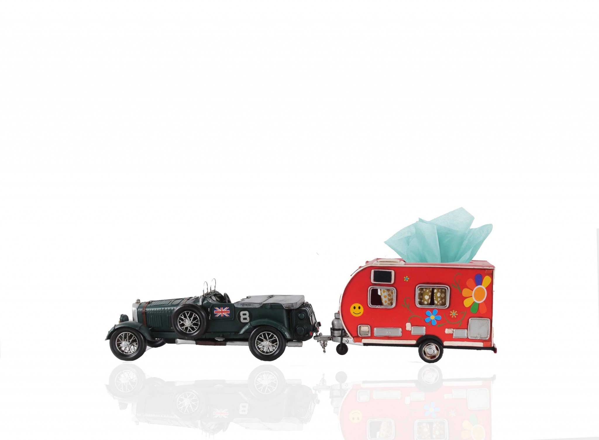 A vibrant red camper trailer tissue holder with floral accents, designed to hold standard tissue boxes, featuring an opening at the back for easy refills.