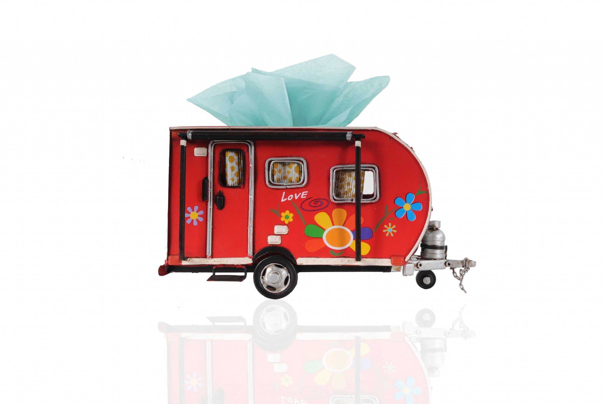 A vibrant red camper trailer tissue holder with floral accents, designed to hold standard tissue boxes, featuring an opening at the back for easy refills.