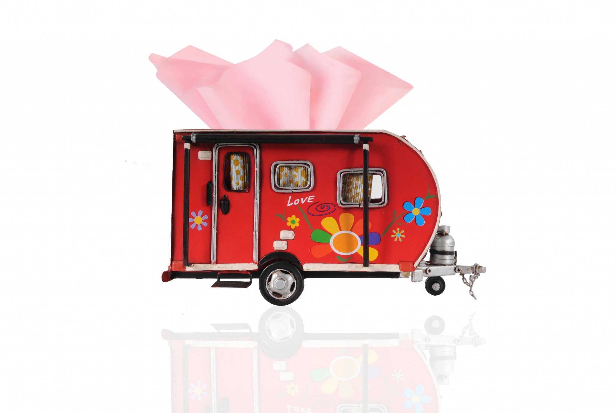 A vibrant red camper trailer tissue holder with floral accents, designed to hold standard tissue boxes, featuring an opening at the back for easy refills.