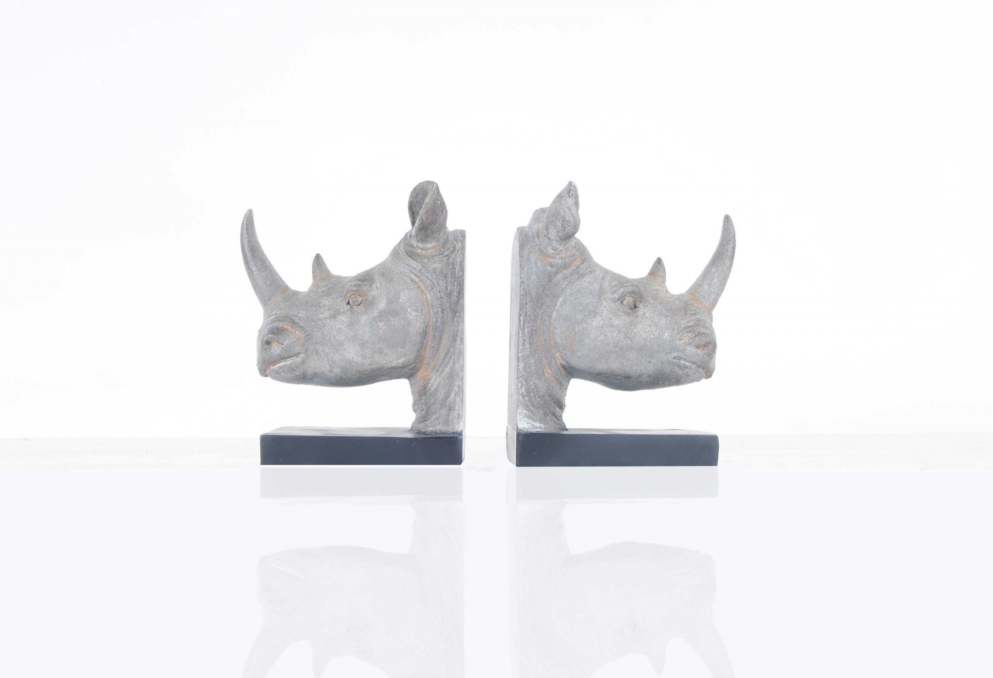 A set of two resin bookends featuring intricately designed rhino heads in dark grey with bronze accents, perfect for holding books upright.