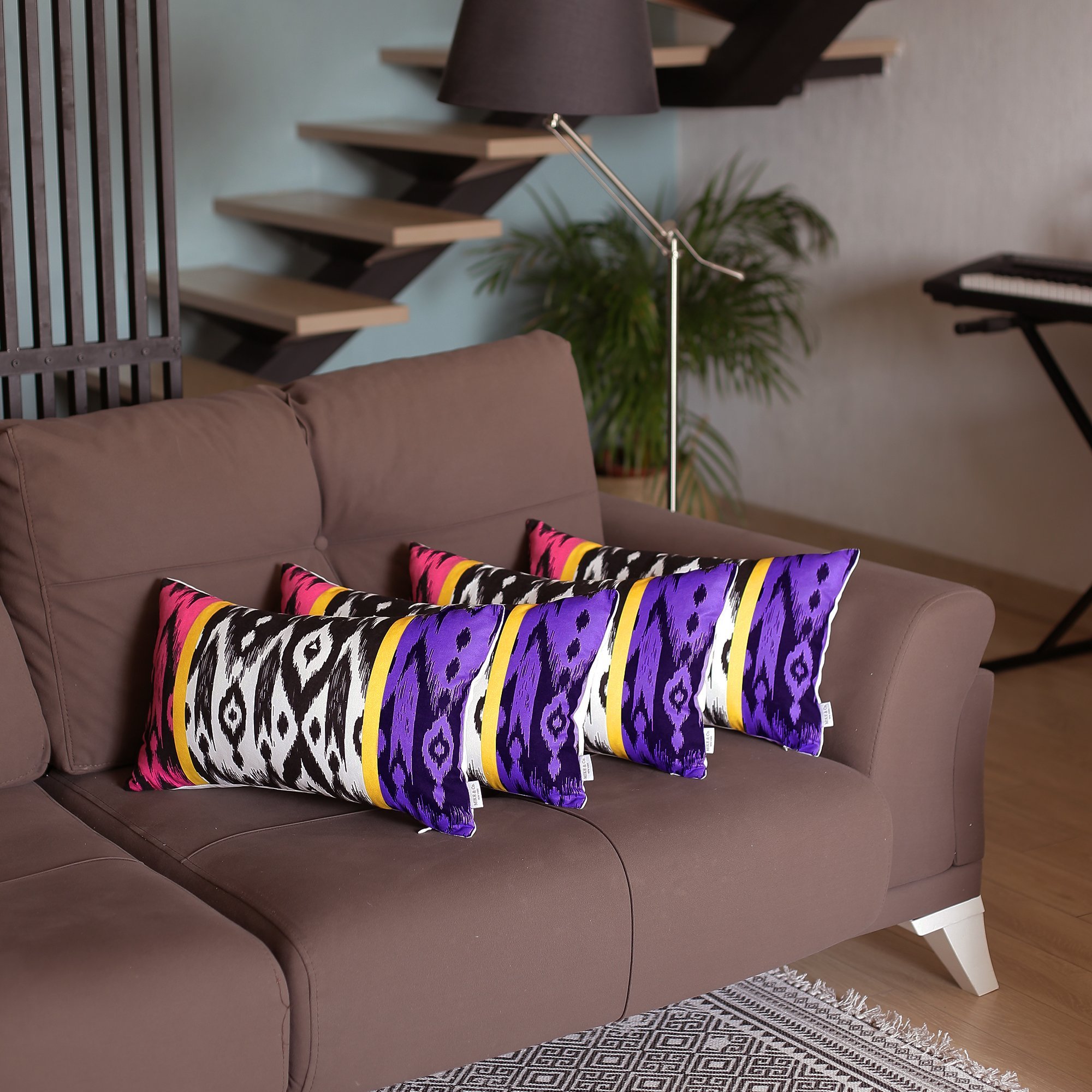 Set of 4 colorful lumbar pillow covers featuring a vibrant ikat design in brown, blue, purple, and pink, made from soft brushed polyester.