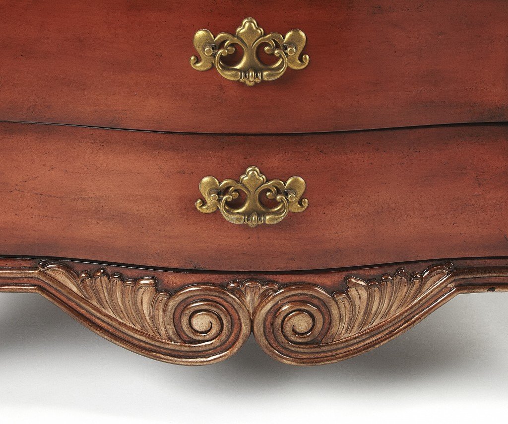 Traditional carved chest featuring a black fossil stone top and antique brass hardware, showcasing intricate woodwork and elegant design.