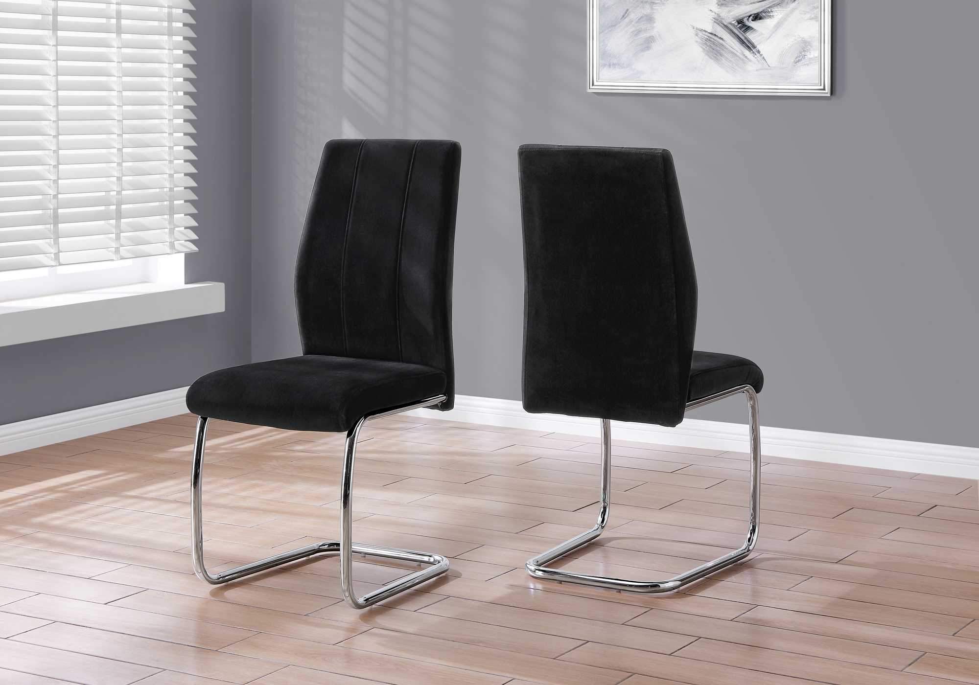 Two elegant velvet dining chairs with chrome metal legs, showcasing a modern design and comfortable foam cushioning.