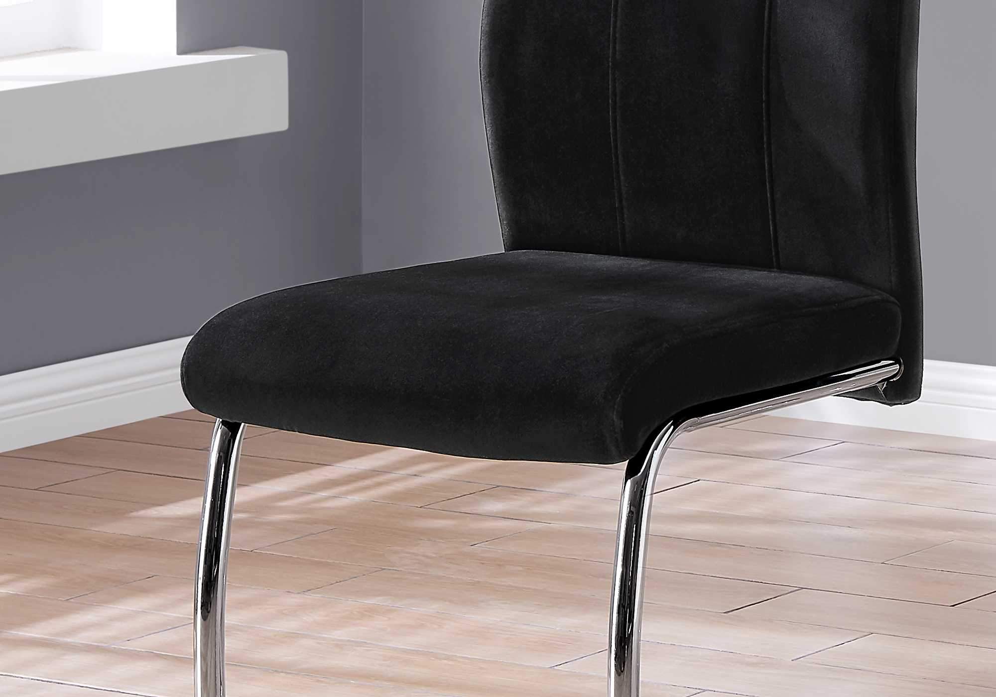 Two elegant velvet dining chairs with chrome metal legs, showcasing a modern design and comfortable foam cushioning.