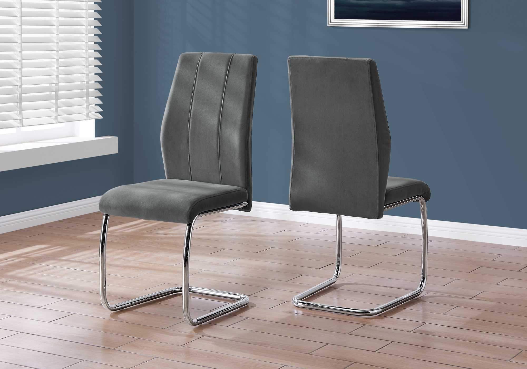 Two elegant velvet dining chairs with chrome metal legs, showcasing a modern design and comfortable foam cushioning.