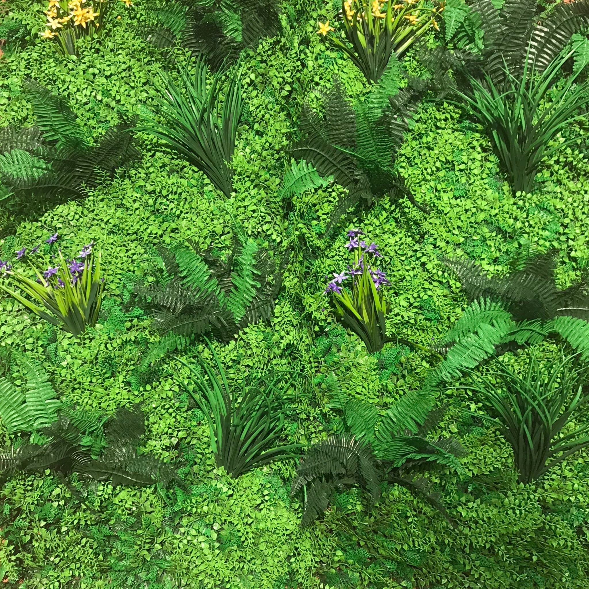 Flame Resistant Artificial Green Wall Hedge Panel measuring 100 x 100 cm, featuring a mix of lush leaves, grass, and fern for a dense, luxurious appearance.