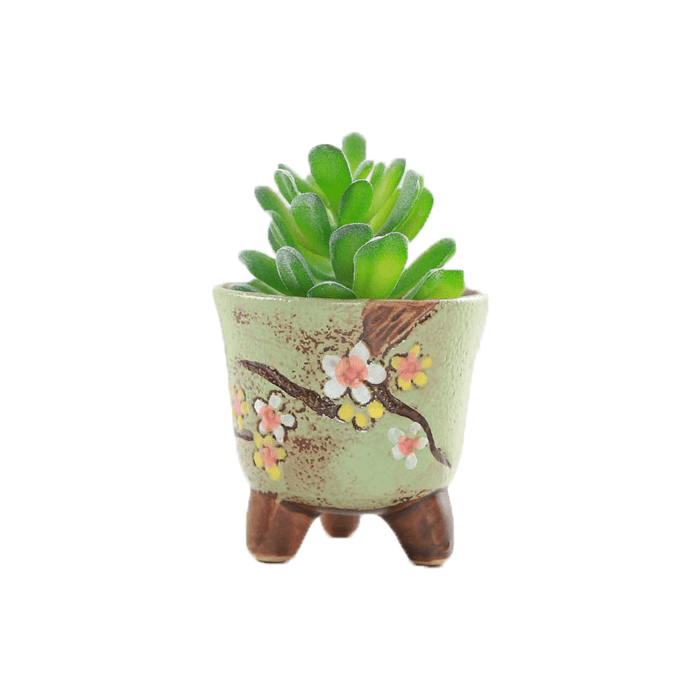 Green cup-shaped ceramic succulent pot with floral design, featuring three legs and drainage hole, perfect for indoor plants.