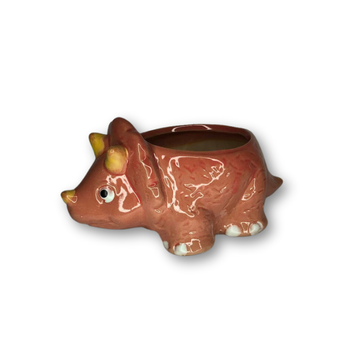 A cute pink ceramic flower pot shaped like a triceratops, featuring a drainage hole at the bottom.