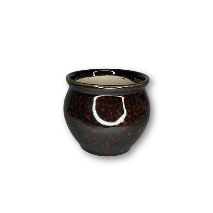 A vibrant red and black glazed ceramic pot with a drainage hole, perfect for indoor plants.