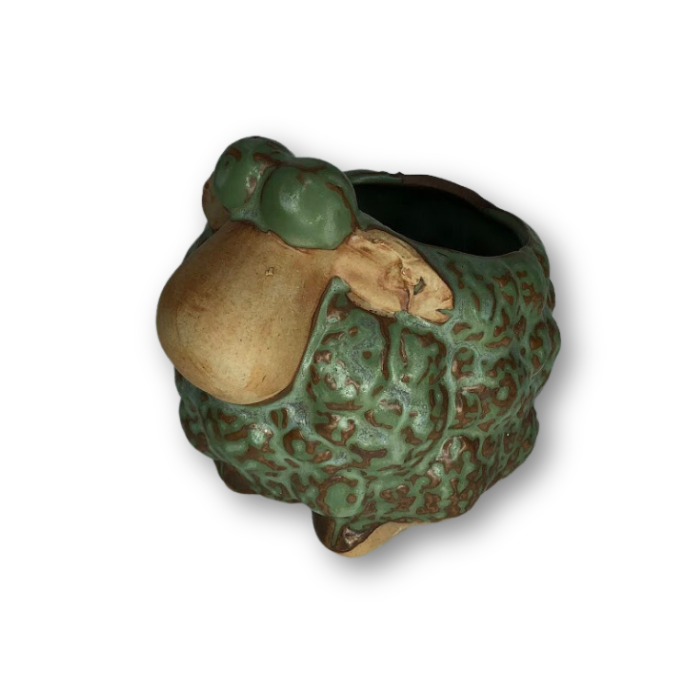 A rustic antique green flower pot shaped like a sheep, featuring a drainage hole at the bottom.