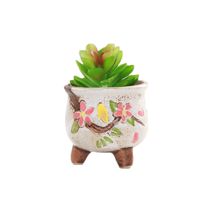 White pear-shaped ceramic succulent pot with floral design, sitting on three legs, perfect for indoor plants.