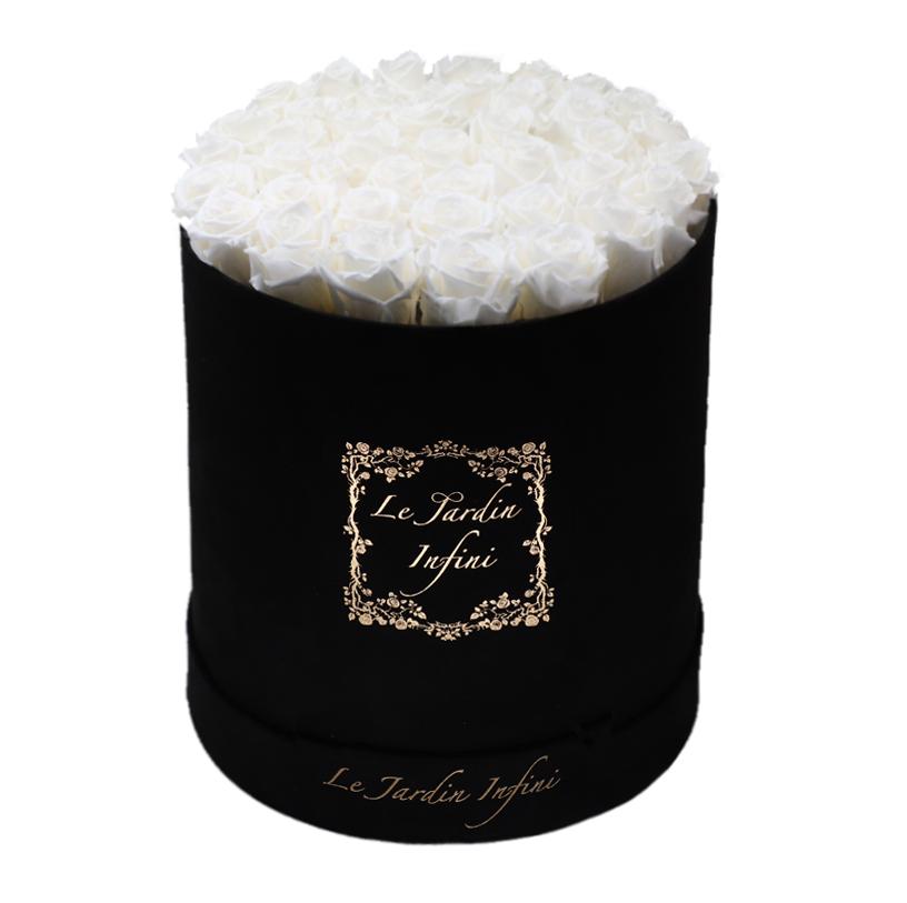 Large round black suede box filled with elegant white preserved roses, showcasing their beauty and luxury.