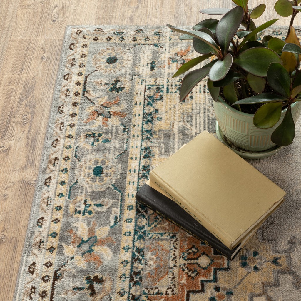 A 10x13 inches gray and beige Aztec pattern area rug featuring intricate floral designs and vintage diamond motifs.