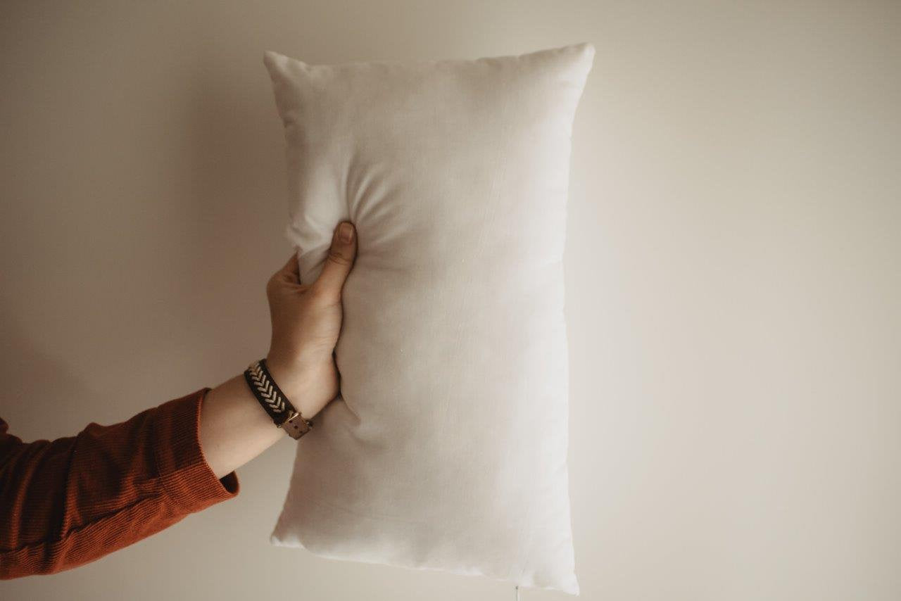 A plush 12x16 or 16x12 hypoallergenic polyester pillow insert, showcasing its soft texture and durable woven cotton blend fabric.