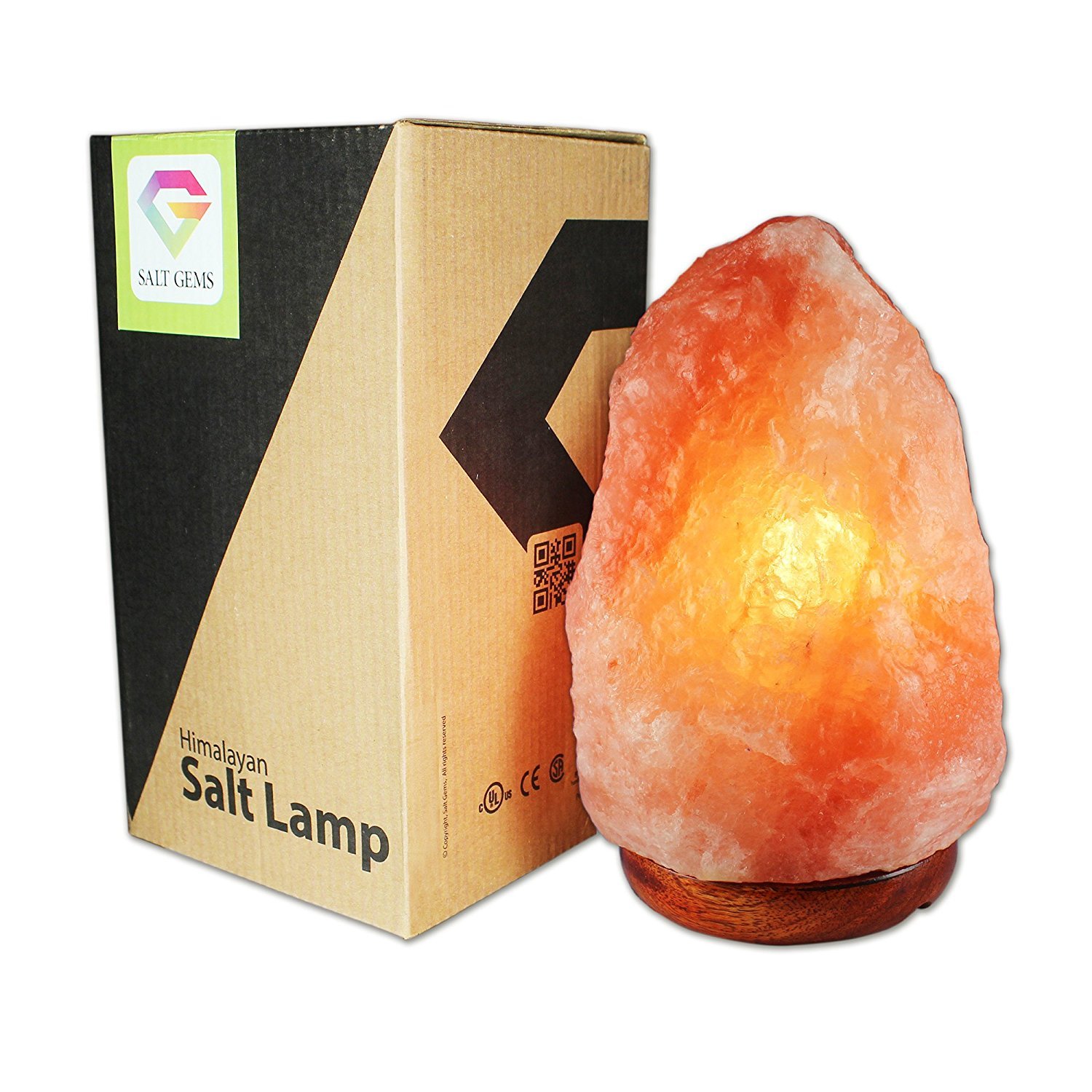 A pair of hand-carved Himalayan salt lamps with unique shapes, emitting a warm amber glow, placed on a wooden surface.