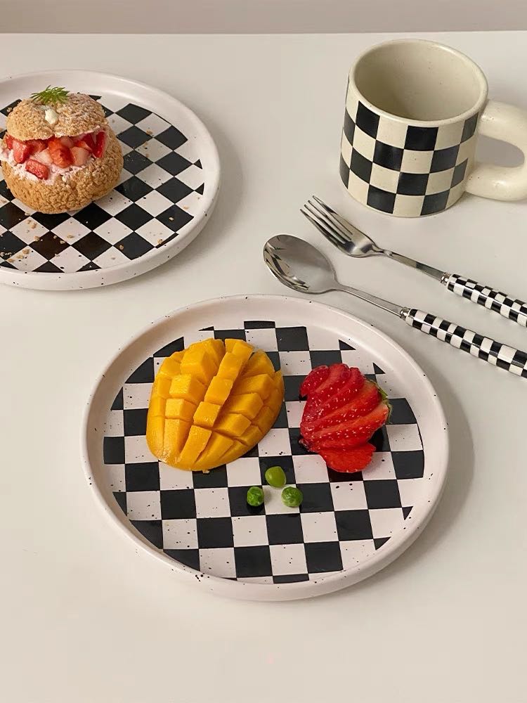 A vibrant 6-pack modern checkered flatware set featuring stainless steel utensils with colorful ceramic handles in red, yellow, green, and black.