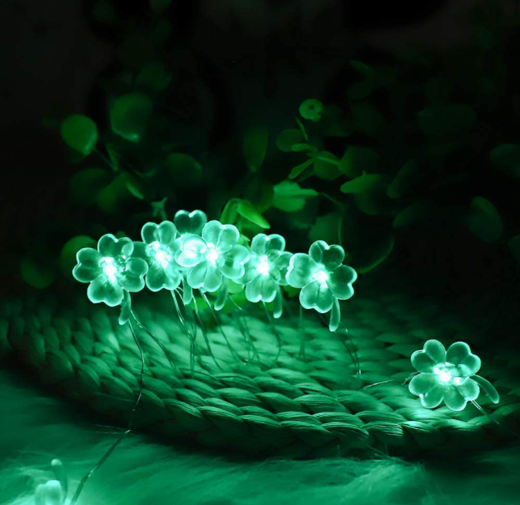 9.8FT string light featuring 30 handmade four-leaf clover LED lights, glowing green for festive decoration.