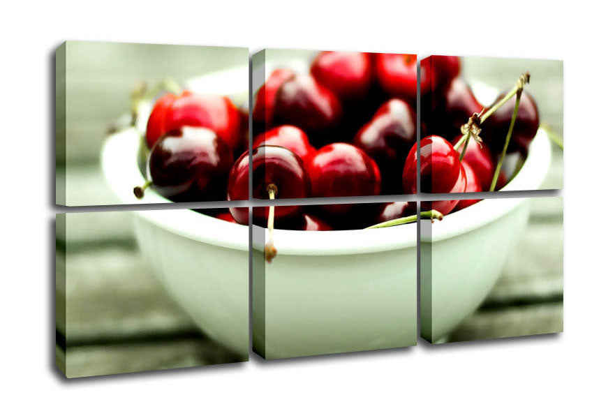 A vibrant canvas artwork featuring a bowl full of cherries, mounted on a sturdy box frame, ready to hang.