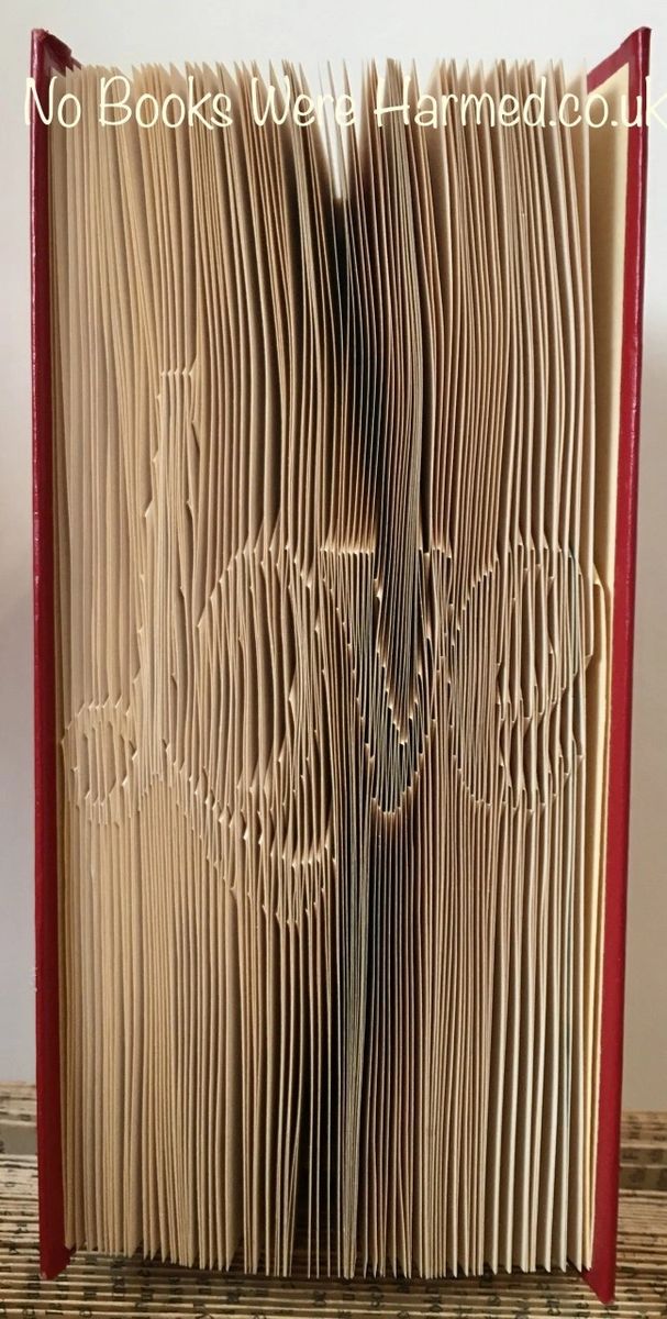 Hand-folded book art featuring the word 'Love', crafted from vintage books, showcasing unique colors and designs.