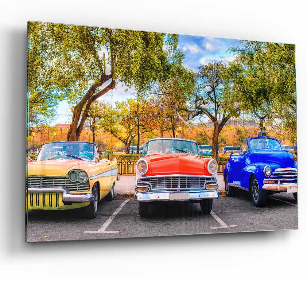 A vibrant glass print featuring three classic American muscle cars, showcasing their sleek designs and powerful presence.