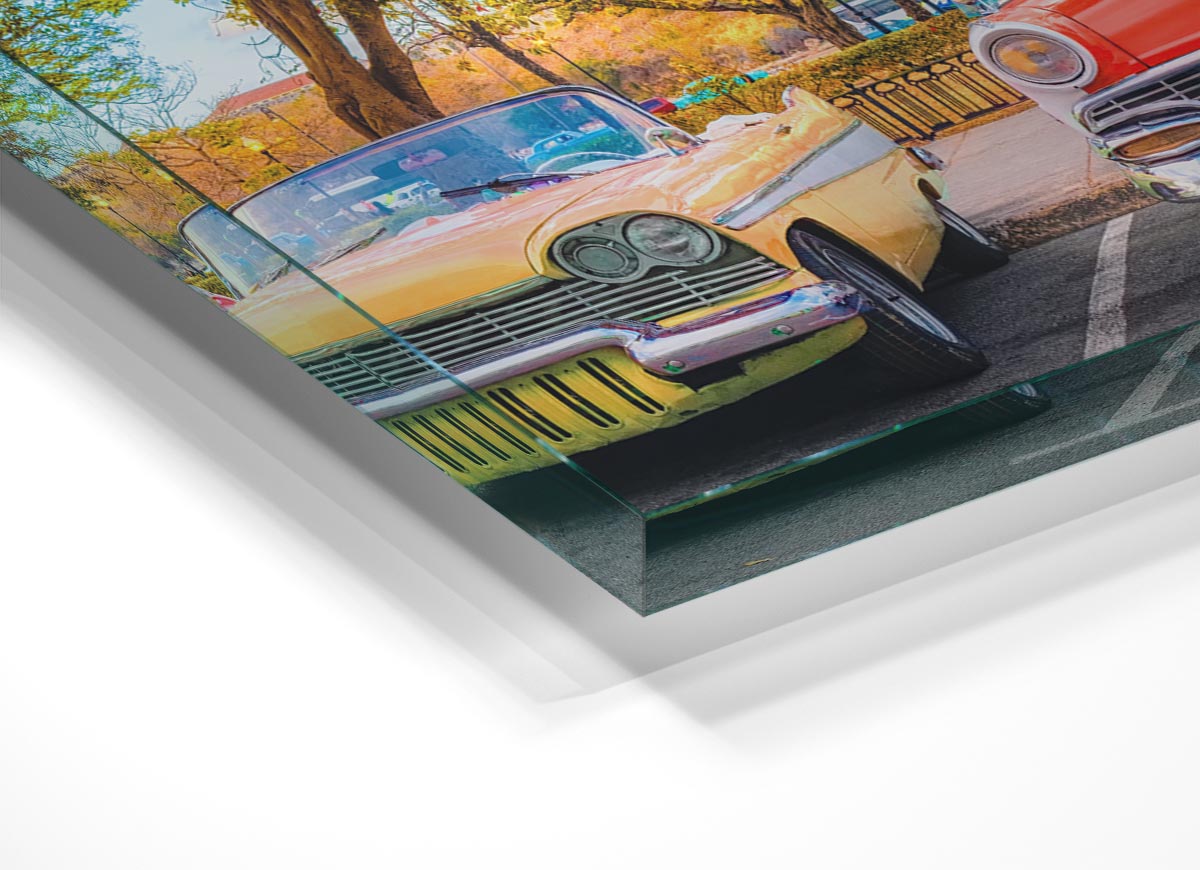 A vibrant glass print featuring three classic American muscle cars, showcasing their sleek designs and powerful presence.