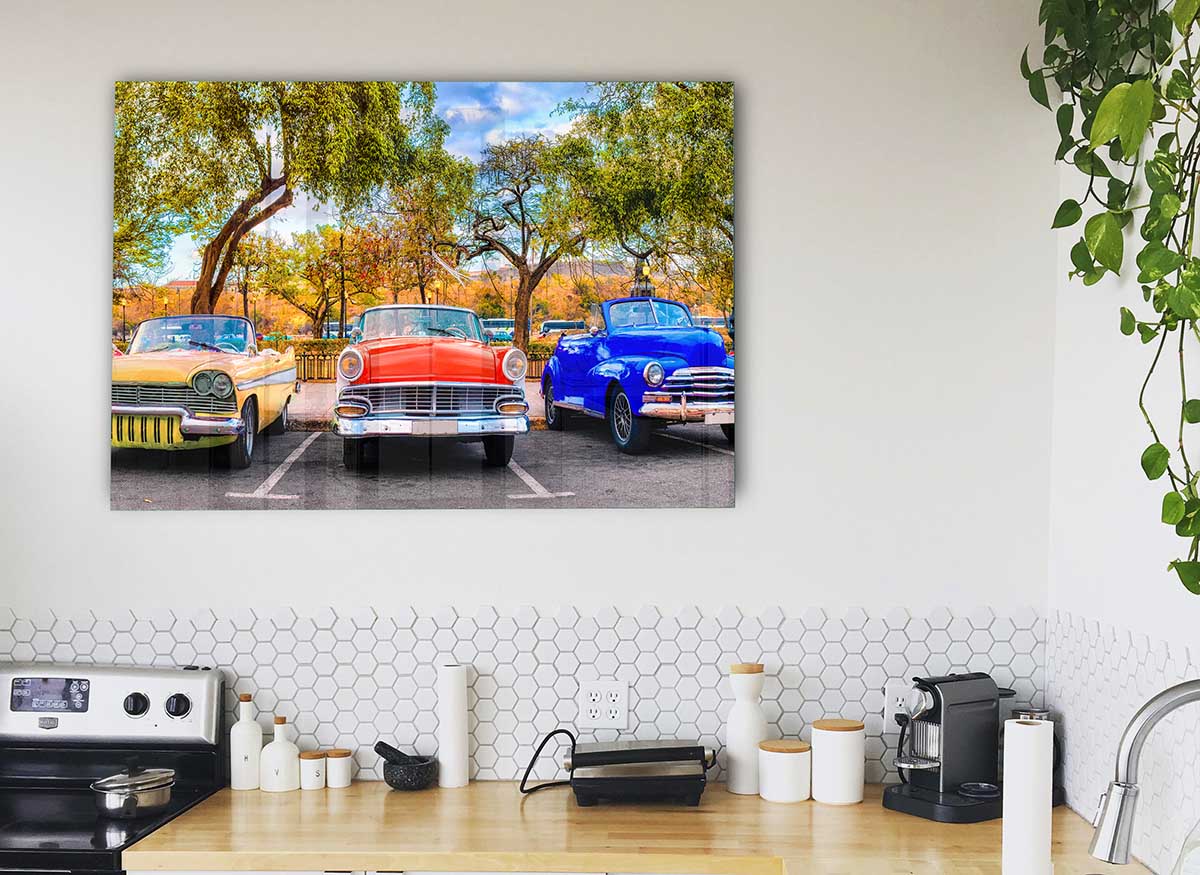 A vibrant glass print featuring three classic American muscle cars, showcasing their sleek designs and powerful presence.