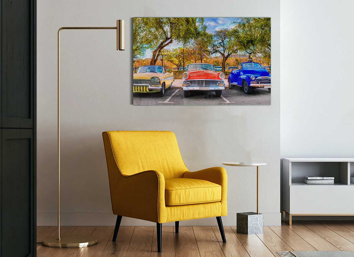 A vibrant glass print featuring three classic American muscle cars, showcasing their sleek designs and powerful presence.