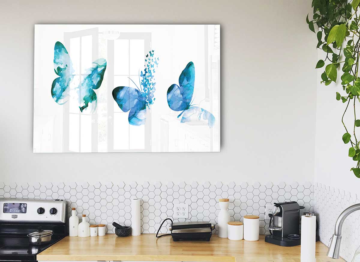 A beautiful glass print featuring three blue butterflies, showcasing vibrant colors and intricate details, perfect for modern home decor.