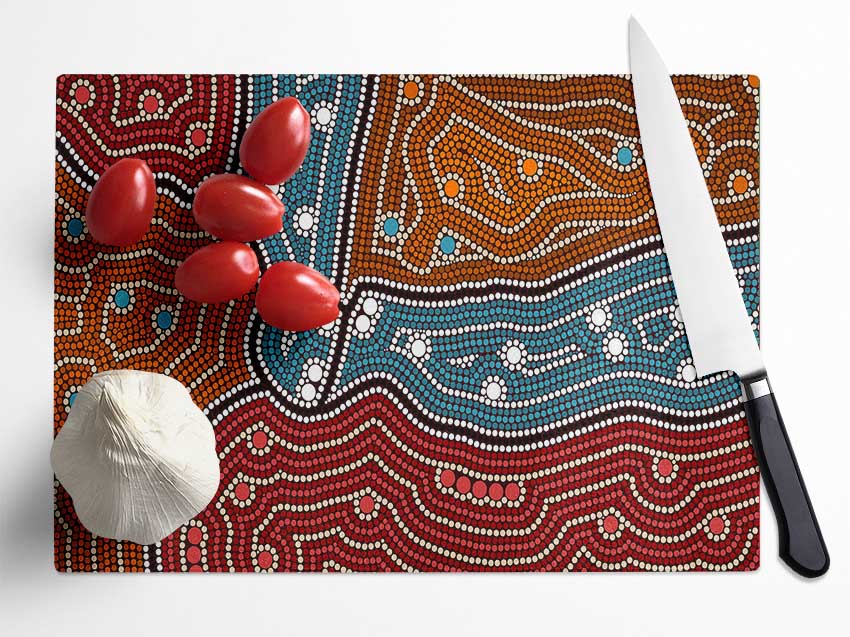 Aboriginal Pattern 4 chopping board made of tempered glass with a chinchilla ripple effect and anti-slip feet.