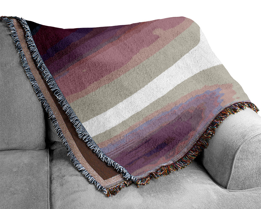 A luxurious Abstract Sun Lilac throw blanket made from 100% cotton, featuring a beautiful thermal weave, draped elegantly over a couch.