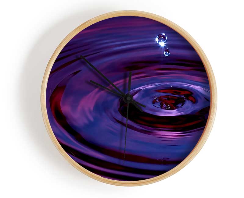 Abstract Drop clock made from natural bamboo with a round face and clear Plexiglas lens, available in black, white, and natural frame colors.