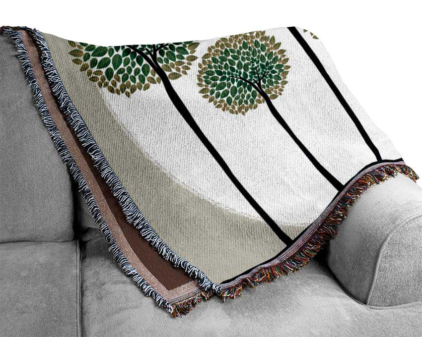 A luxurious Abstract Trees throw blanket made from 100% cotton, featuring a unique abstract tree pattern in soft, neutral tones.