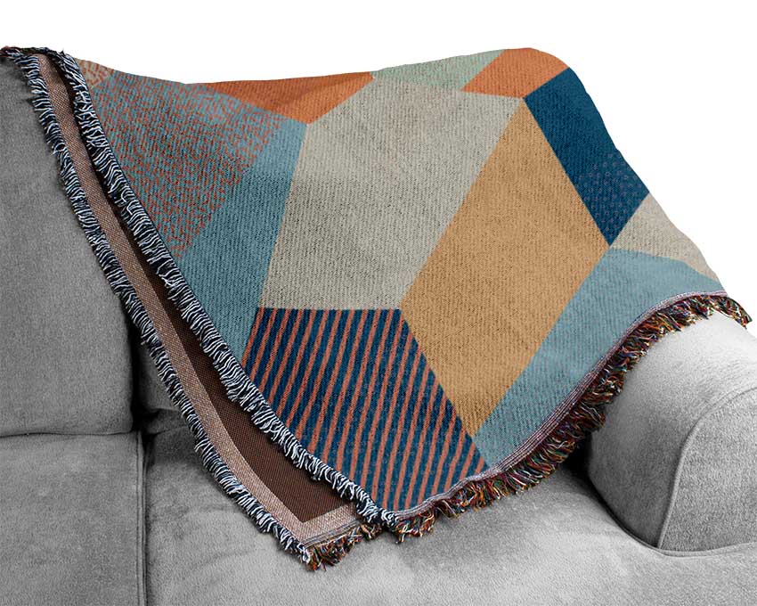 A luxurious Abstract Triangles throw blanket made from 100% cotton, featuring a stylish geometric design in soft colors, perfect for home decor.