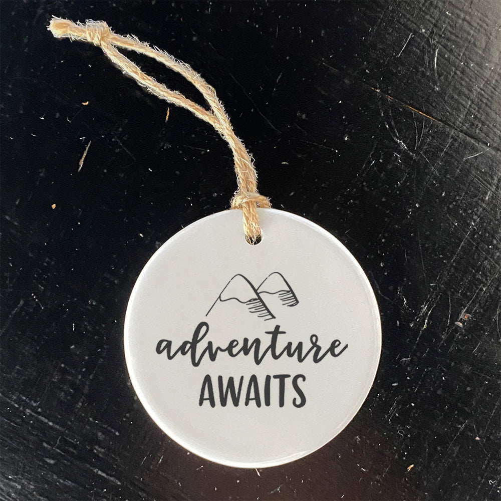 Adventure Awaits ornament featuring mountain design, made of high-quality porcelain with a glossy finish.