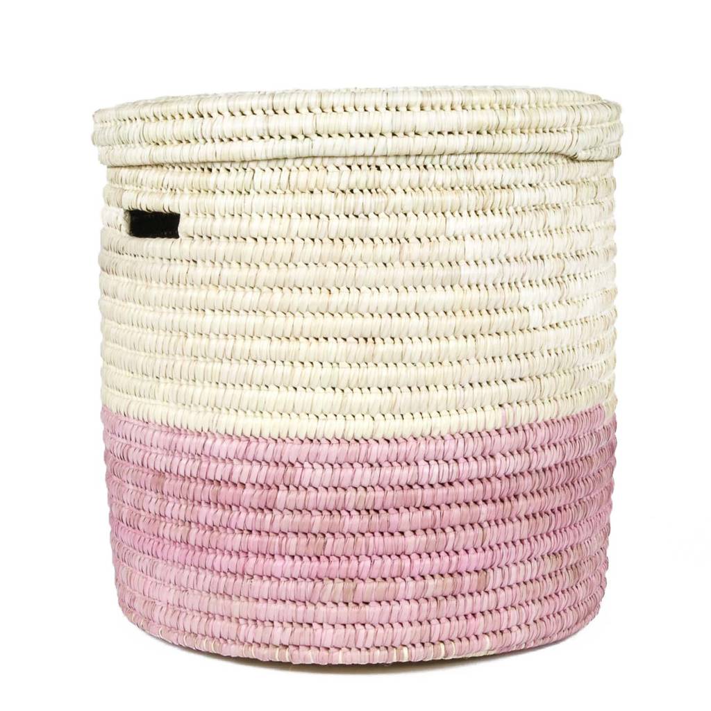 A vibrant African handcrafted laundry basket made from doum palm leaf, featuring a raspberry pink color block design, showcasing its lidded structure and unique craftsmanship.