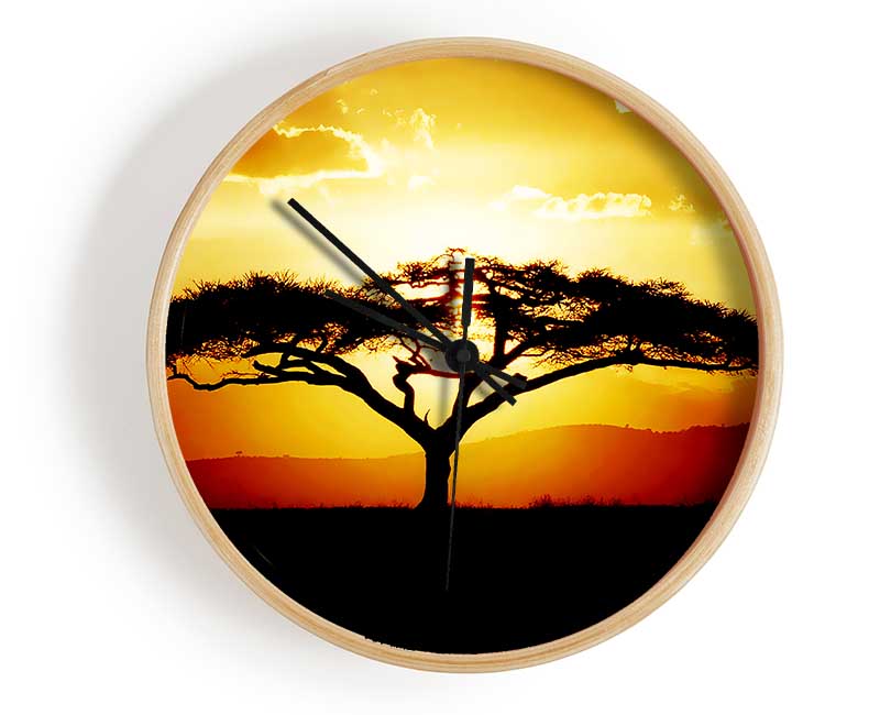 A stylish clock featuring an African tree silhouette against a vibrant sunset, crafted from natural bamboo.