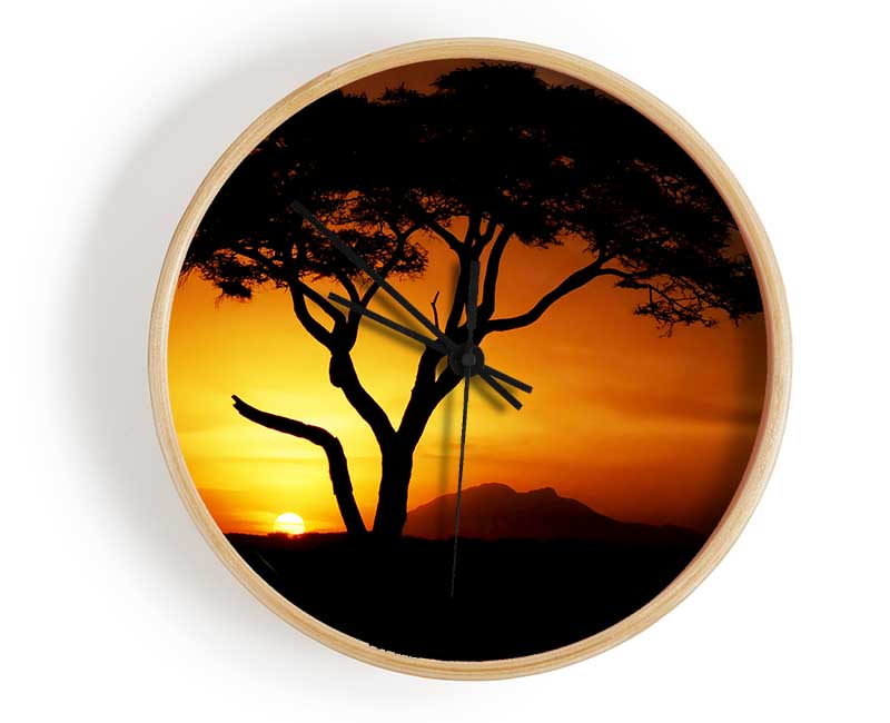 A beautifully designed clock featuring an African tree silhouette against a golden sunlight background, made from natural bamboo.