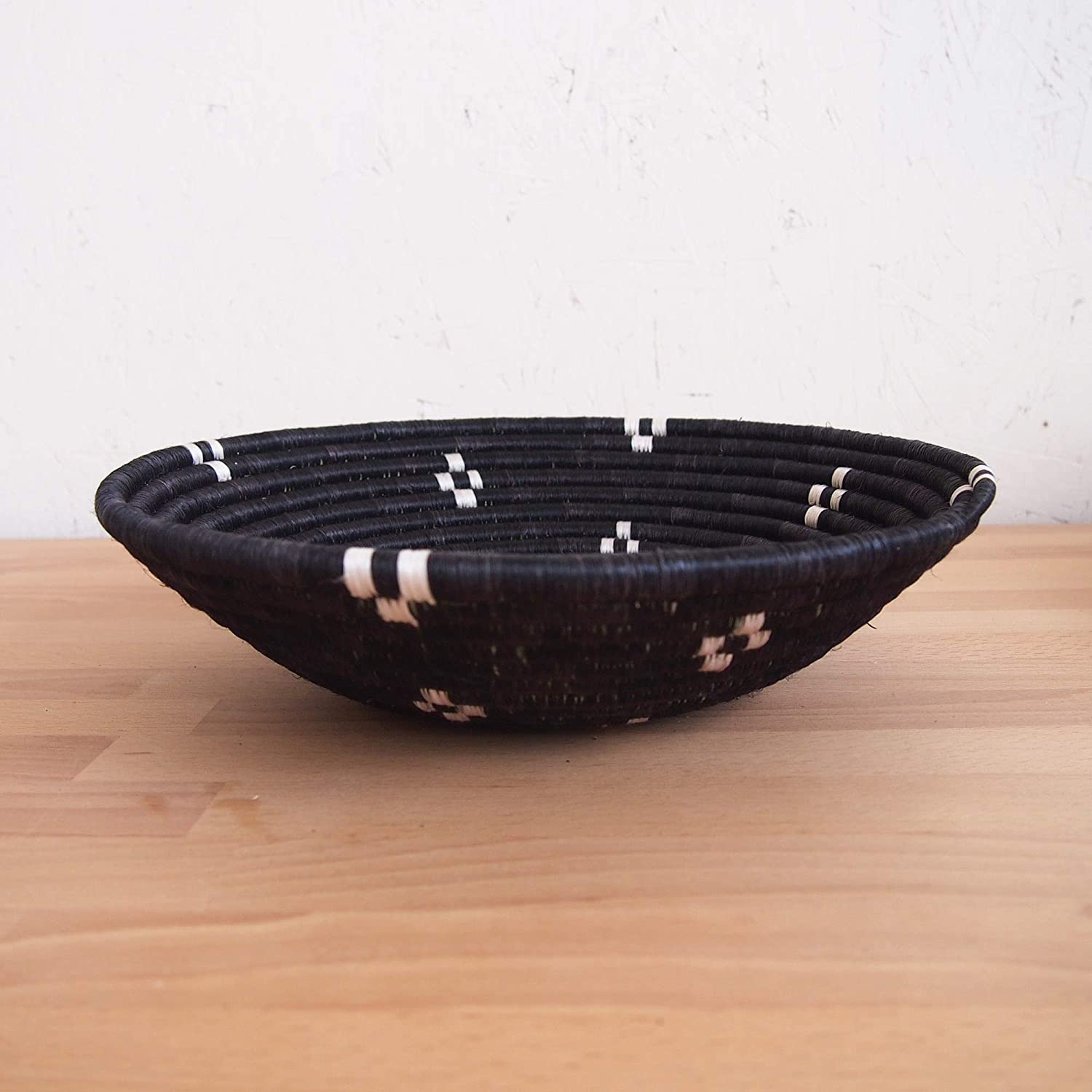 A beautifully crafted African woven basket made from raffia grass, showcasing intricate designs and vibrant colors, perfect for wall decor or fruit display.