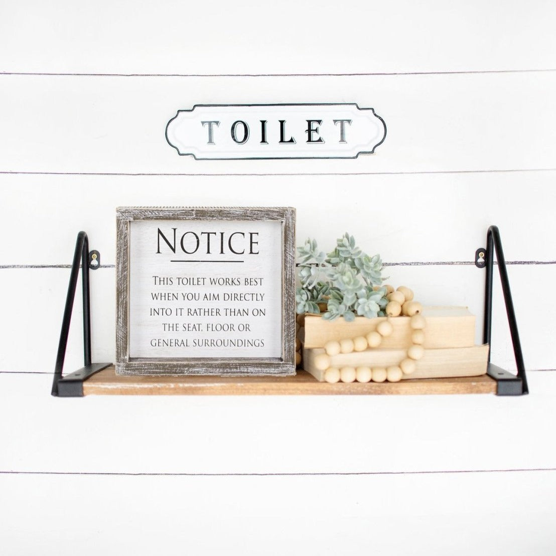 A stylish framed wood sign that reads 'Aim It!' in black and white, perfect for bathroom decor.