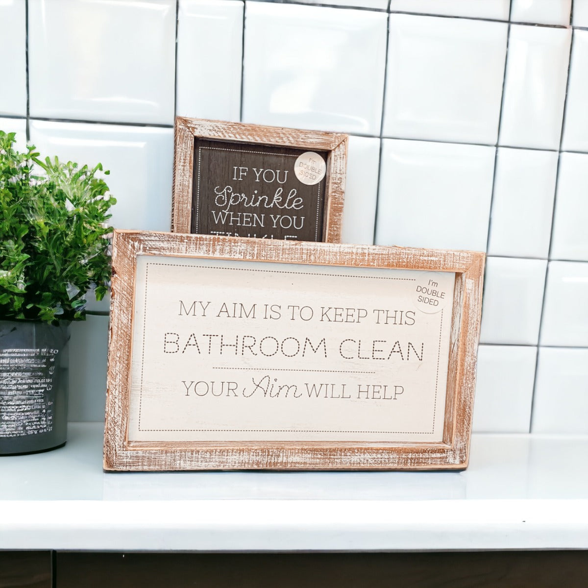 Aim + Sprinkle Tinkle double-sided bathroom sign with wooden frame, featuring humorous cleanliness messages.