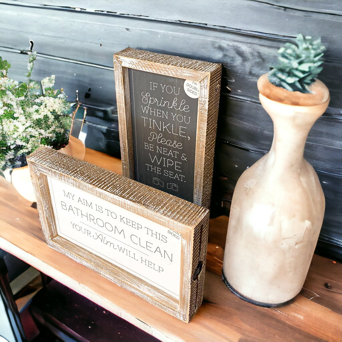 Aim + Sprinkle Tinkle double-sided bathroom sign with wooden frame, featuring humorous cleanliness messages.