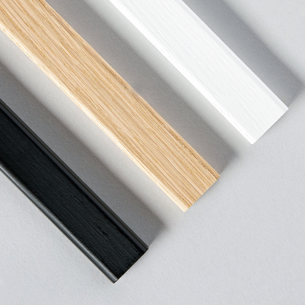 Slimline wooden poster hangers with magnetic fastening, showcasing prints in black, white, and natural oak finishes.