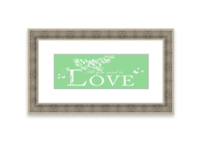 Framed print of 'All You Need Is Love' in green, showcasing vibrant colors and a heartfelt message, ready to hang.