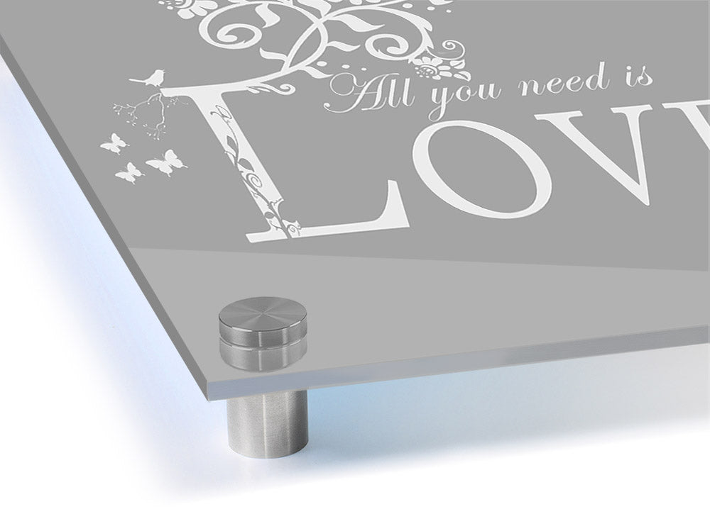 All You Need Is Love Grey White acrylic print on a wall, showcasing its elegant design and vibrant colors.