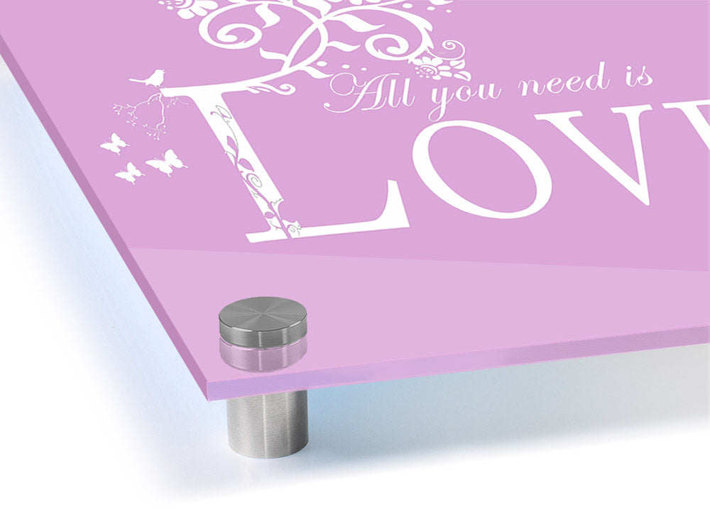 All You Need Is Love Pink acrylic print on a wall, showcasing vibrant pink colors and modern design.