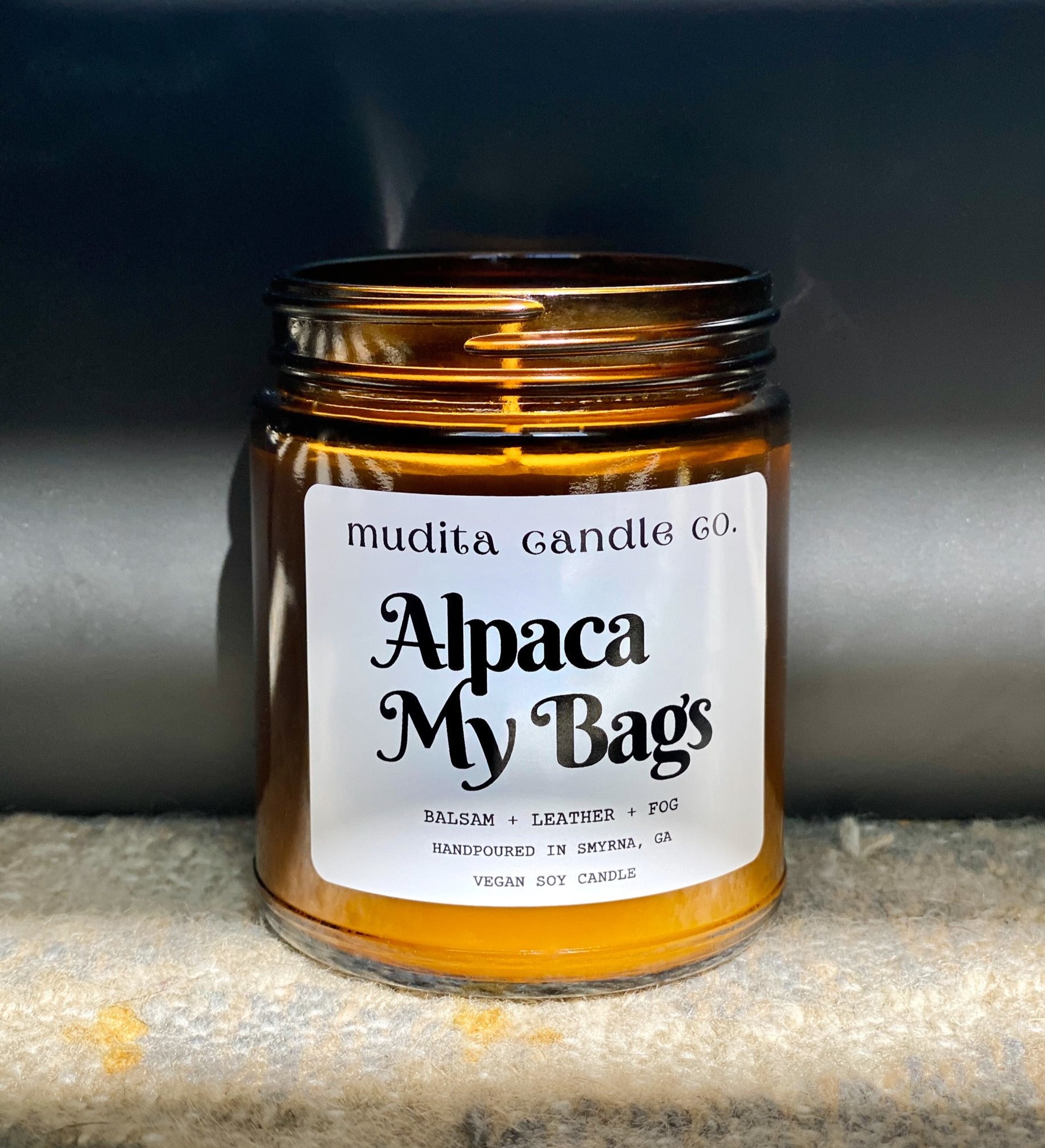 Alpaca My Bags Balsam Leather Soy Candle in amber glass jar with gold lid, showcasing its cozy and inviting scent.