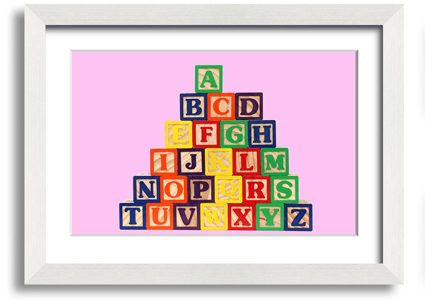 A charming pink framed print featuring colorful alphabet blocks, perfect for nursery decor.