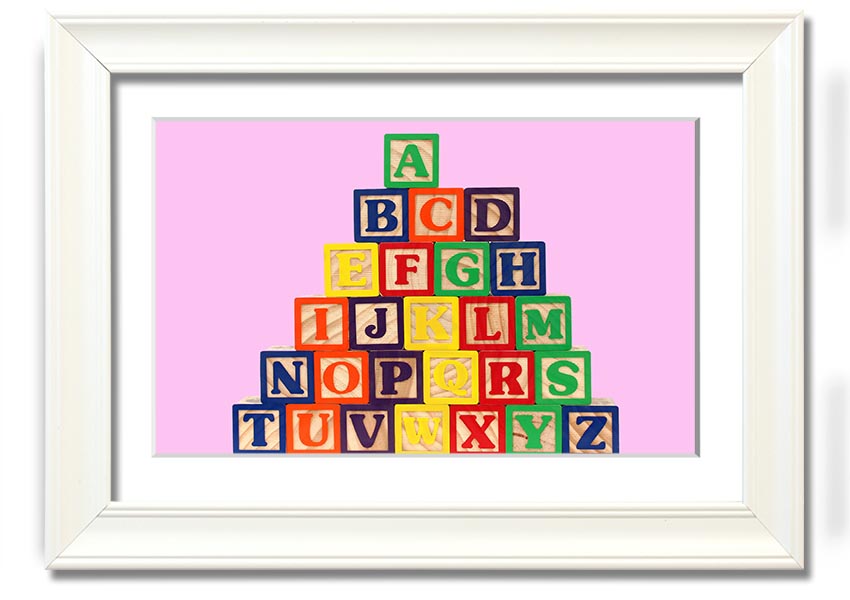 A charming pink framed print featuring colorful alphabet blocks, perfect for nursery decor.