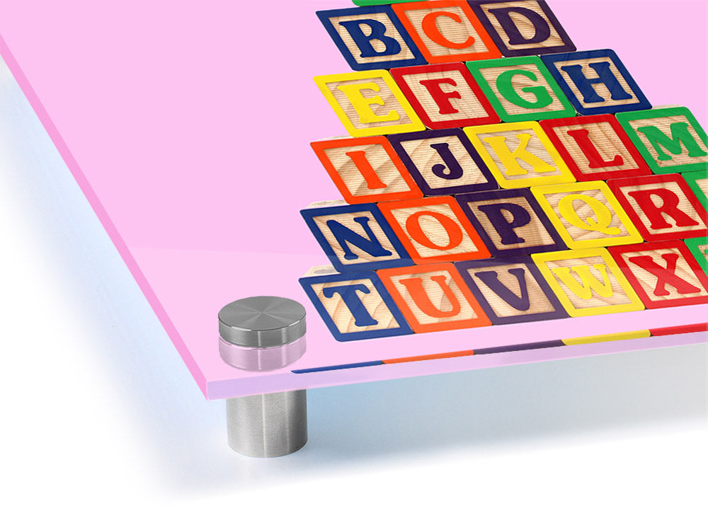 A vibrant pink acrylic print featuring colorful alphabet blocks, perfect for children's decor.