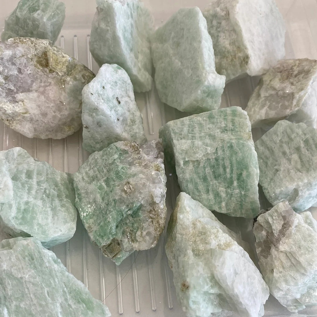 A collection of Amazonite Rough Cut stones showcasing unique shapes and pale aqua colors, perfect for jewelry and ceramics.